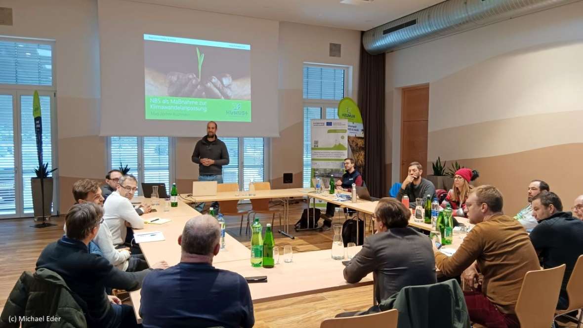 Die Teilnehmer:innen gemeinsam an einem Tisch beim Austausch und diskutieren. 